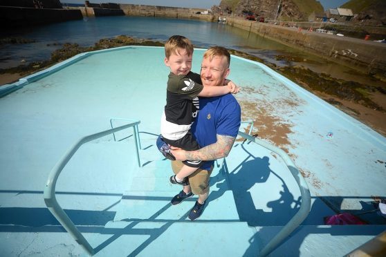 Steven Farquhar helps look after Portknockie at the paddling pool he has just finished doing it up for summer.  Also in the photo is his son Alex, 5