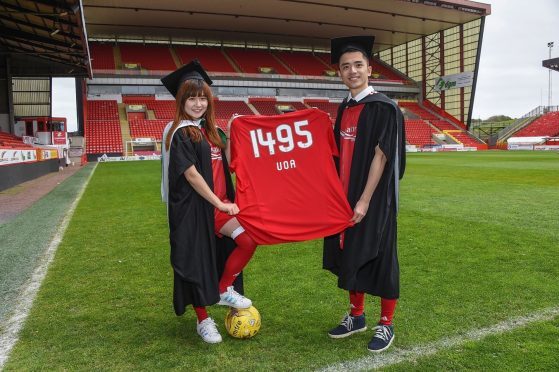 Aberdeen University students Beiqiao Gu, left, and Weipeng Liu show off their Dons’ colours