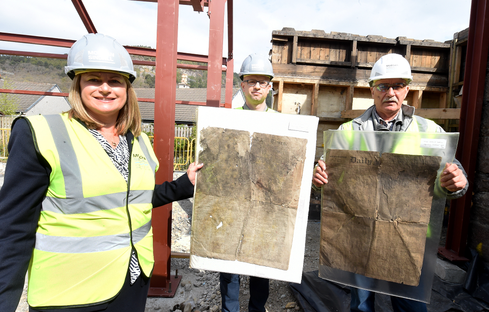 Old newspapers found during the rebuilding at the railway site, The Square, Ballater. In the picture are from left: Janelle Clark, Marr area manager: Graig Matheson, project manager and Mike Murchison, general forman.