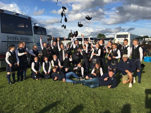 Lochalsh Junior Pipe Band members and tutors celebrate their achievement at St James Park, Paisley in the British Pipe Band Championships