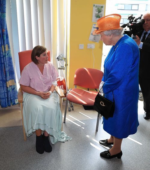 Queen Elizabeth II speaks to Ruth Murrell who was injured, along with her daughter Emily, 12