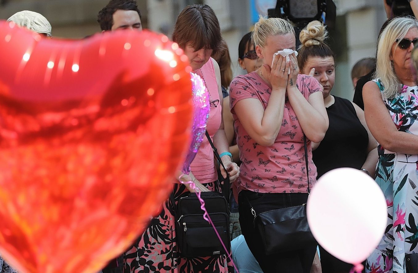 People look at tributes in St Ann's Square, Manchester, before a minute's silence to remember the victims of the terror attack