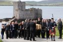 BARRA, UNITED KINGDOM - JUNE 5:  Roddy MacLeod, Eilidh's father leads the funeral procession as it passes Kisimul Castle on its way to the Church of Our Lady, Star of the Sea, in Castlebay on Barra