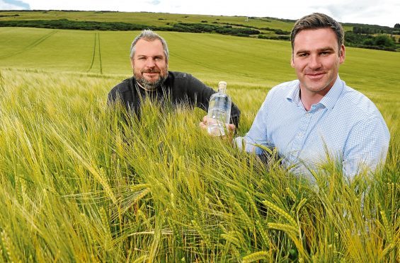 Stuart Wells and Ed Scaman with a bottle of their produce.