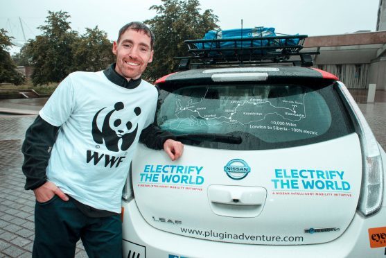 Chris Ramsey next to his Nissan Leaf