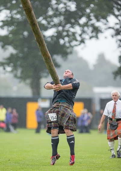 A competitor tosses the caber at the Inverness Highland Games.