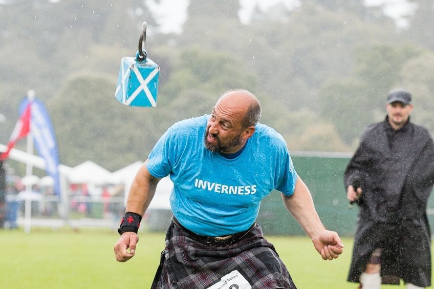 A competitor moves out of the way as the Weight Over the Bar comes down at the Inverness Highland Games.