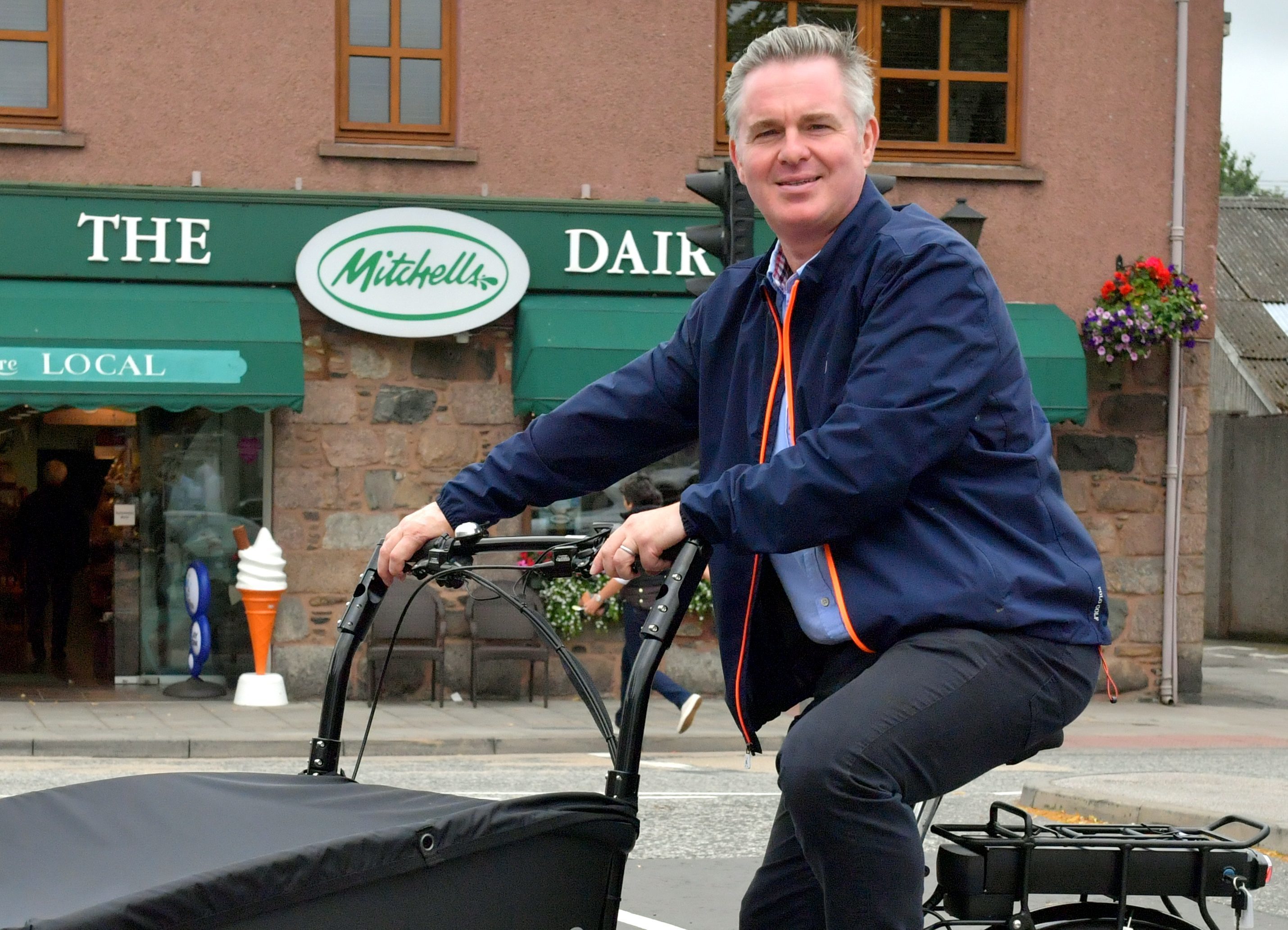 Mitchells Dairy, Inverurie have obtained an electric bike to make local deliveries from the shop, as part of a council initiative.    
Pictured - Colin Clark MP tries out the new electric delivery bike.    
Picture and video by Kami Thomson