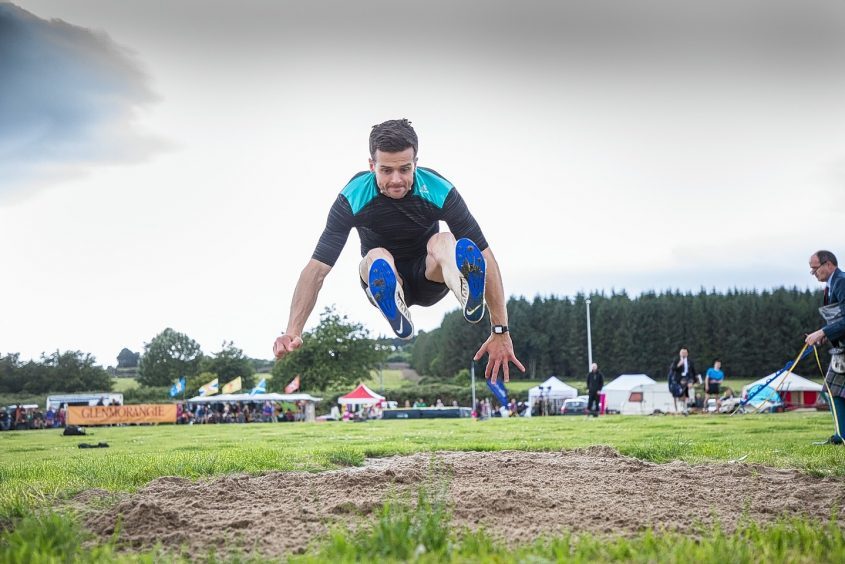 Flying high; Tony Daffurn lands a record jump of 6.68metres at the Tain Highland Gathering.