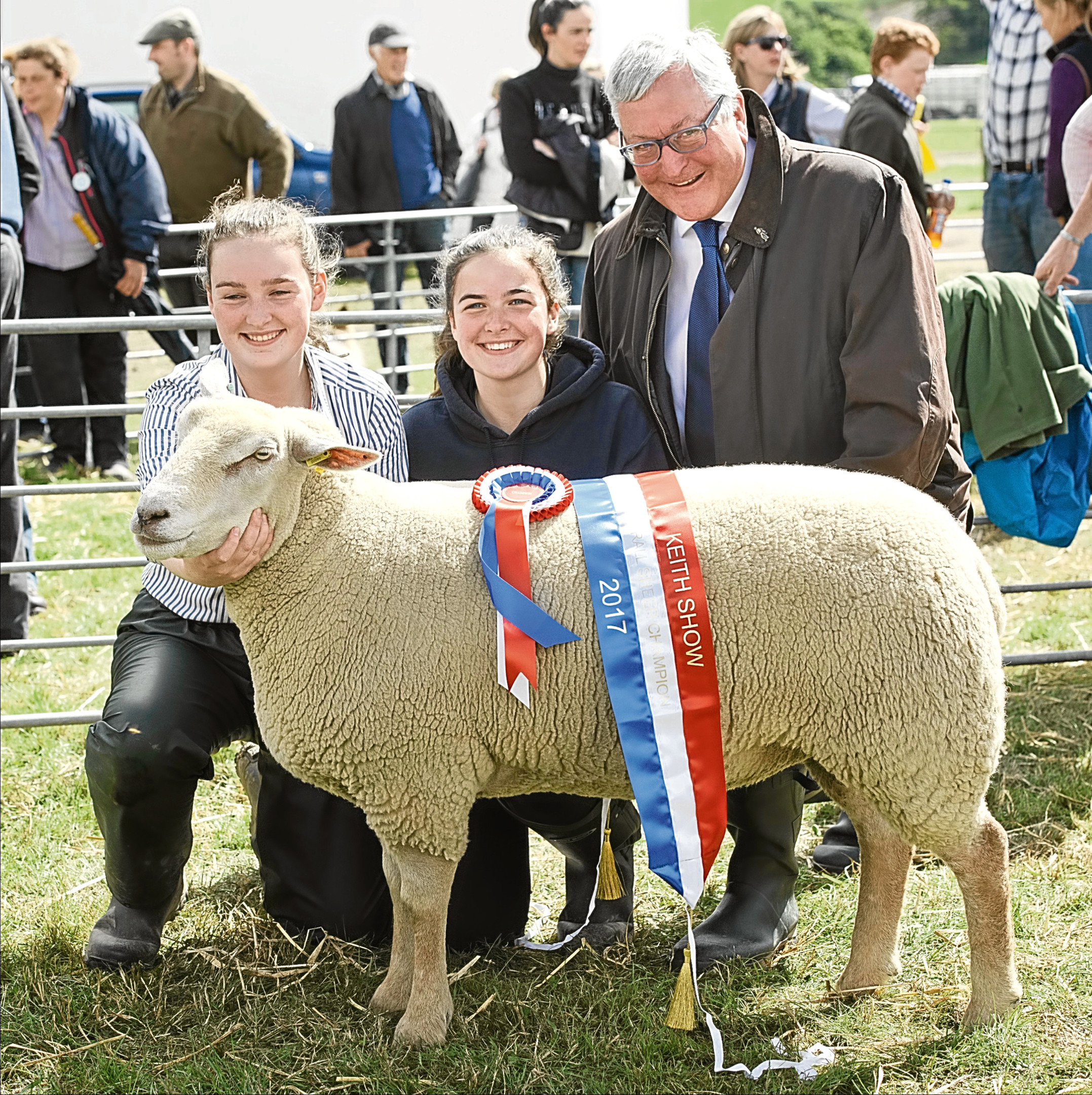 Rural Economy Secretary Fergus Ewing presents Erin and Eilidh Duncan with the sheep interbreed championship rosette.