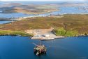 The extended quay at Dales Voe, Lerwick Harbour, provides the offshore industry with the strongest quay in the UK, at 60 tonnes per square metre. The Buchan Alpha floating production unit, which recently arrived for decommissioning, is seen in the foreground. Credit: John Coutts.