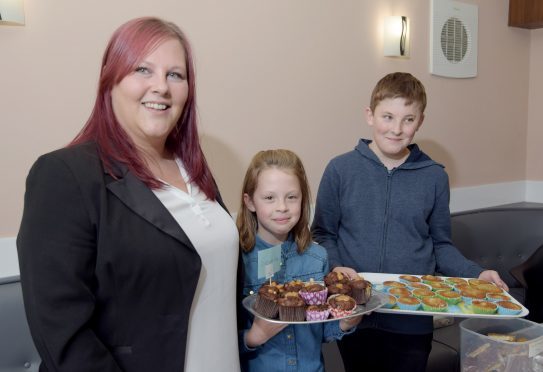 Gary Campbell's partner, Leanne Crawford,  with helpers Lauryn MacKenna (9) and Kye Crawford (12) at the home baking stall at Sunday's fun day.
PICTURE IAIN FERGUSON, THE WRITE IMAGE