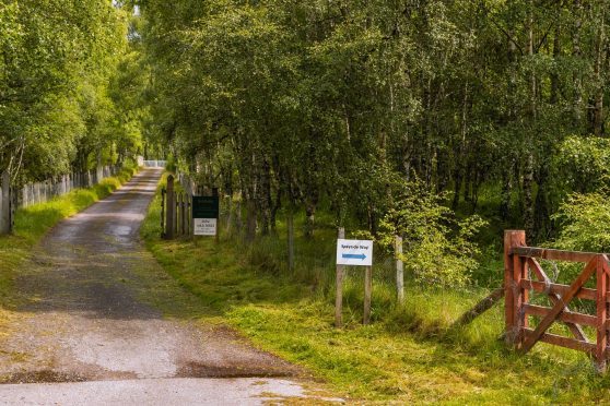 The entrance to Kinrara Estate from adjacent to Dalraddy Holiday Park, with a sign directing away from the ropad to the Speyside Way gate.