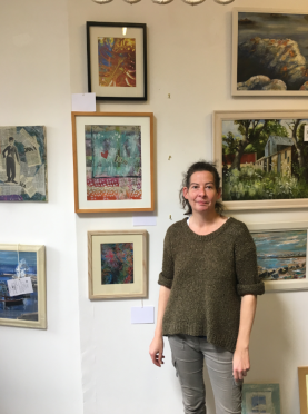 Artist Mandy Middler stands in front of some her work