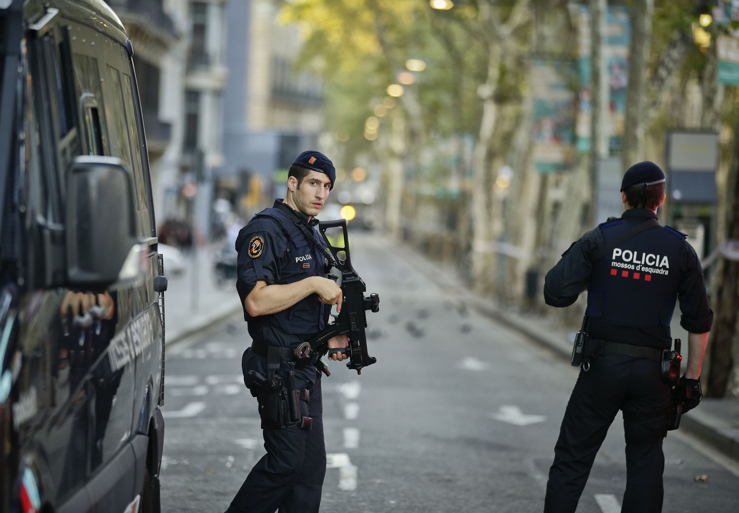 Armed police officers patrol a deserted street in Las Ramblas, in Barcelona, Spain