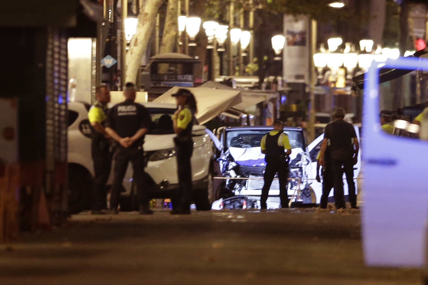 Police officers stand next to the van involved on an attack in La Rablas in Barcelona, Spain