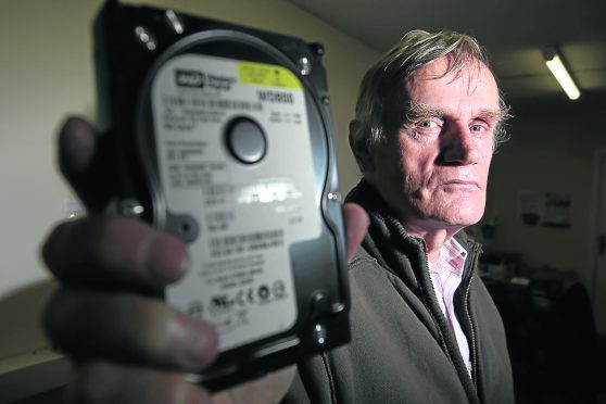 The Rev Richard Burkitt with a hard drive similar to the one connected to his laptop