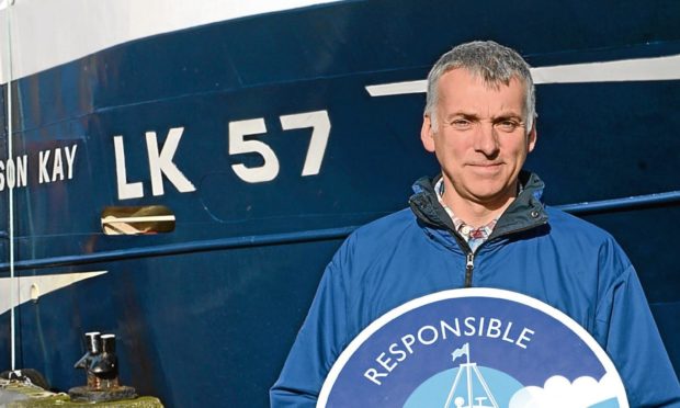 Skipper James Anderson with his boat, the Alison Kay in Scalloway harbour