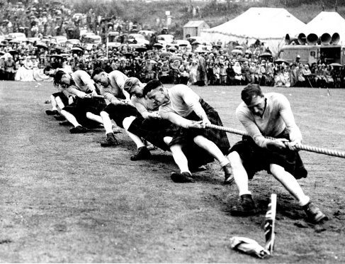 A team get the winning pull at the tug-of-war event in 1954.