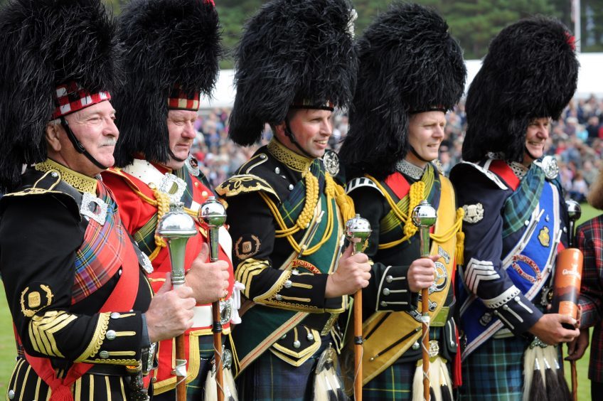 Pipe Majors line up after the mace twirling contest at the Braemar Gathering in 2010