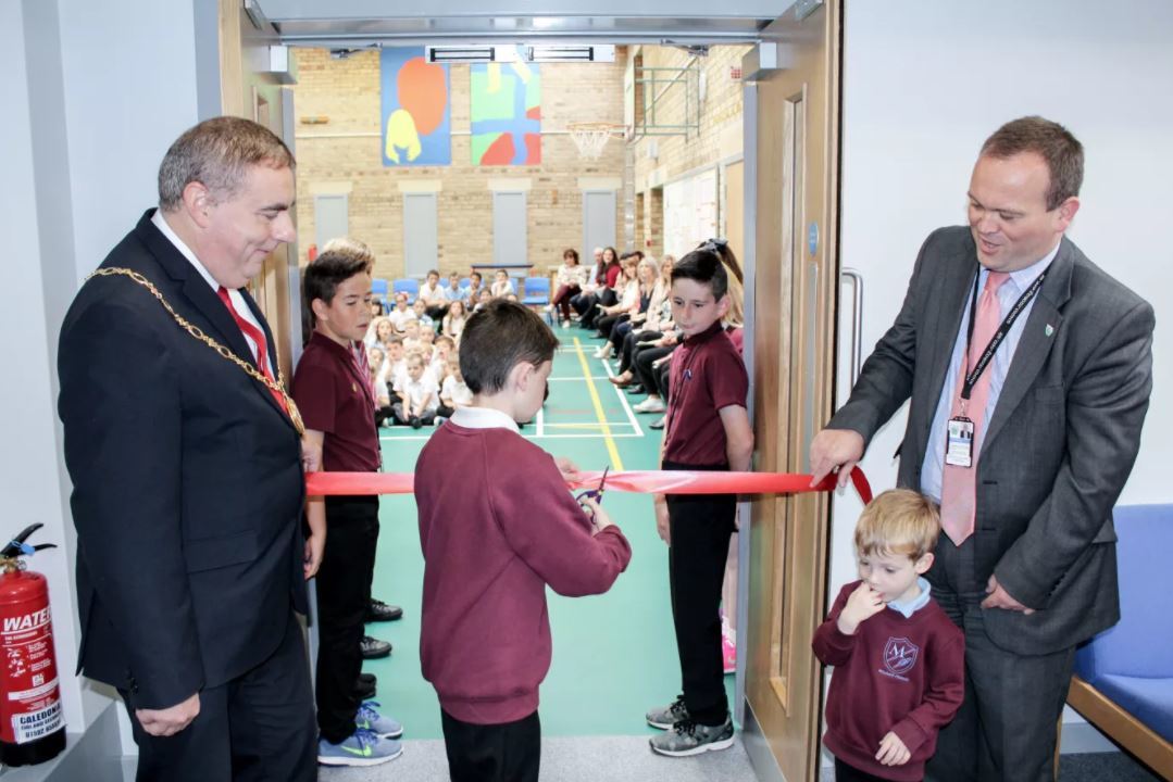 The youngest and oldest pupils at Millbank Primary cut the ribbon while watched by councillor James Allan, left, and the council's director of education, Laurence Findlay, right.