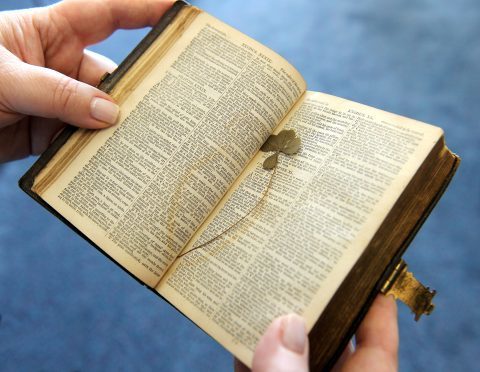 The pocket-sized book, complete with a four-leaf clover tucked among its pages, bears the owner’s name, Alexander MacDonald. Picture by Sandy McCook.