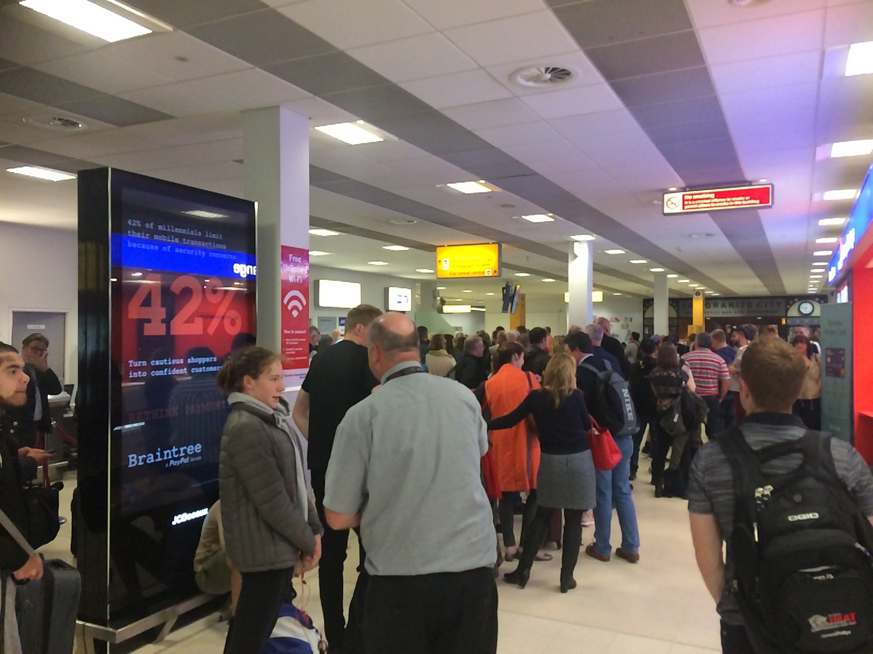 Passengers queue to rebook flights and arrange accommodation after cancellations at Aberdeen Airport.