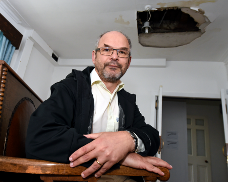 Aberdeen Synagogue president Mark Taylor below the hole caused by the flood