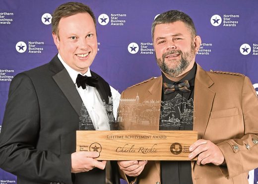 Pictured is Conrad Ritchie accepting the Lifetime Achievement Award on behalf of his late father Charles with awards sponsor Fraser Carr from Cala Homes