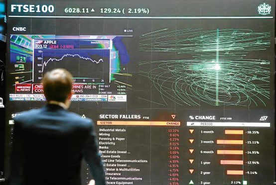 A city worker looks at a stock ticker screen at the London Stock Exchange in the City of London. PRESS ASSOCIATION Photo. Picture date: Tuesday August 25, 2015. The FTSE 100 Index bounced back above the 6,000 mark after surging by nearly 2% as it recovered following one of its worst sessions in recent years. See PA story CITY FTSE. Photo credit should read: Philip Toscano/PA Wire