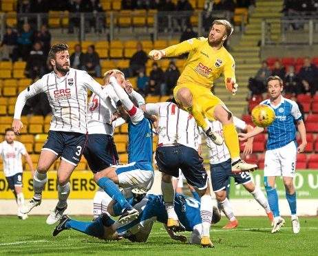 Ross County goalkeeper Scott Fox competes for the ball