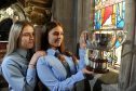 Twins Holly (left) and Lucy Smith of Falkirk and whose family all come from Barra with the McTavishs Kitchen Trophy for Duet Singing.  Picture and video by Sandy McCook.