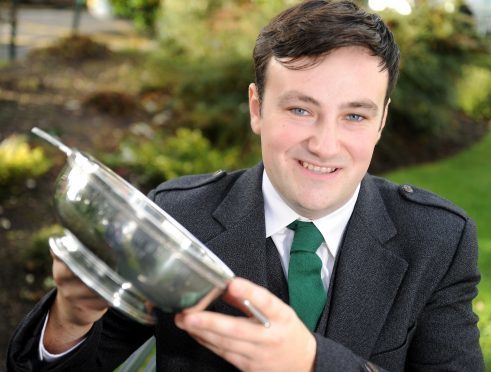 Alasdair MacMhuirich of Islay with the Caledonian MacBrayne Trophy for Solo singing and the FS Cameron HEad Memorial Trophy, also for the Oran Mor. Picture by Sandy McCook.