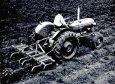 An early period photograph of a Fordson Dexta scrubbing down potatoes.