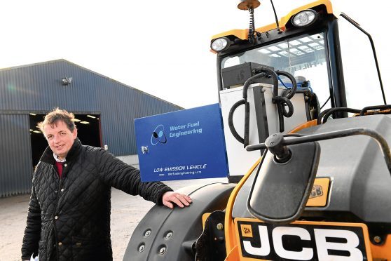 David Barron beside the JCB loader, which has been retrofitted with hydrolyser technology