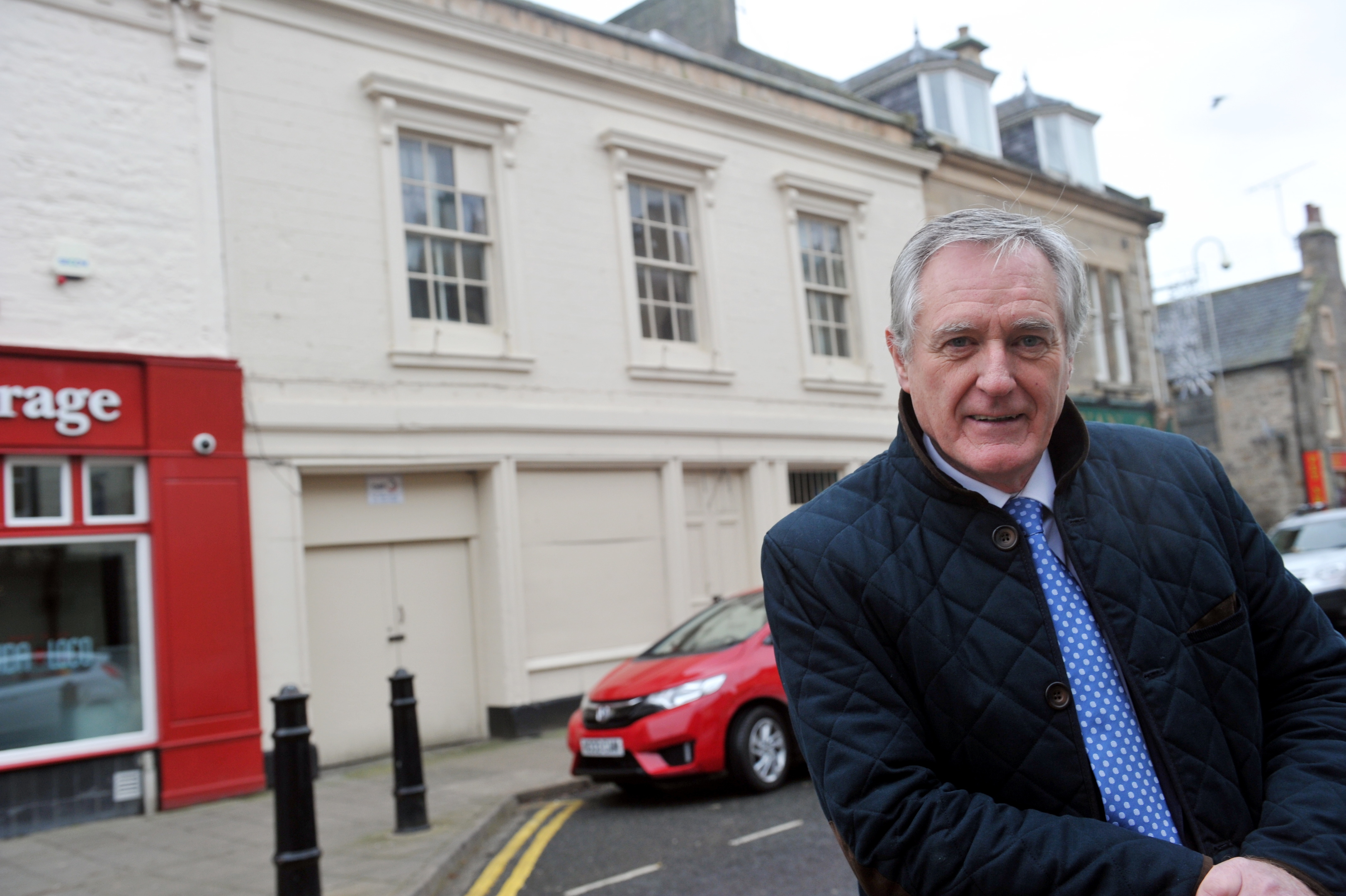 Councillor John Cowe in Elgin's High Street in front of the building he wanted to see demolished.