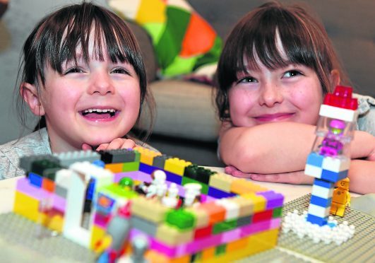 Heather Woollacott (right) with her sister Izzy with a rocket and noodle restaurant made out of lego.    
Picture by Kami Thomson