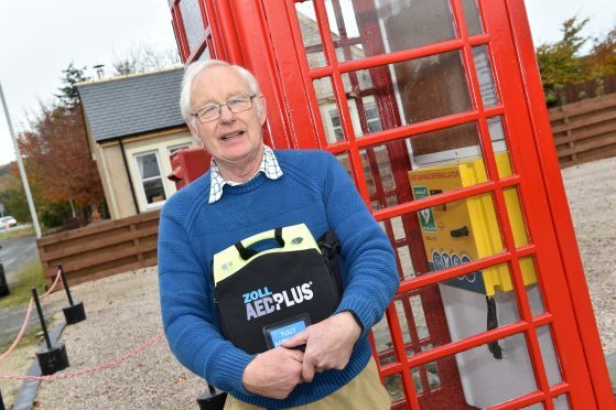The phone box in Colpy which is now housing a new defibrillator. Greg Manning who restored the phone box with the new device.
Picture by Colin Rennie