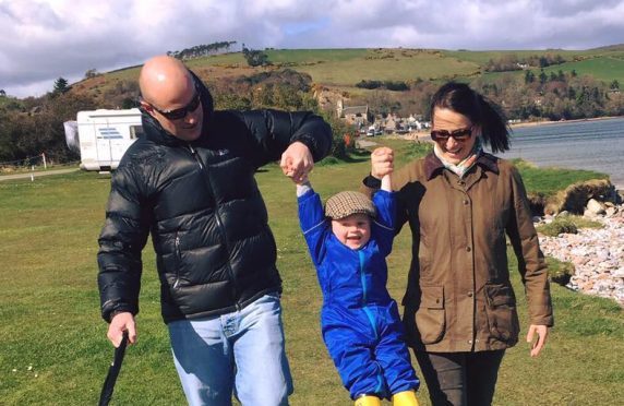 Angus Ross, pictured centre, with parents Steven, left, and Dionne, right.