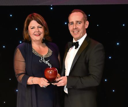 Picture of (L-R) Kay Hopwood collecting it for winner Peter Matthews (Aberdeenshire Council Learning and development team online (ALDO)),  Paul McGuire last year.