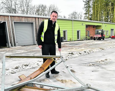 JACK GRANT WITH THE REMAINS OF A GATE WHICH WAS SMASHED.