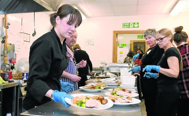 Salvation Army chef Jade Hughes (front) serving up lunches in the kitchen with the help from other volunteers.  
Picture by Kami Thomson