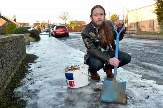 Tiler Colin Gibson has been out gritting pavements outside old peoples homes.

Picture by Kenny Elrick.
