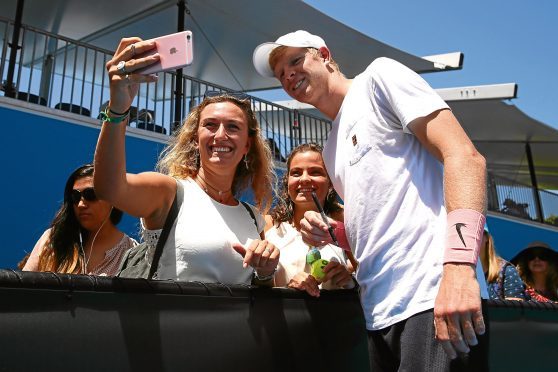 Kyle Edmund of Great Britain poses for photos with fans after completing a practice session on day 10 of the 2018 Australian Open at Melbourne Park