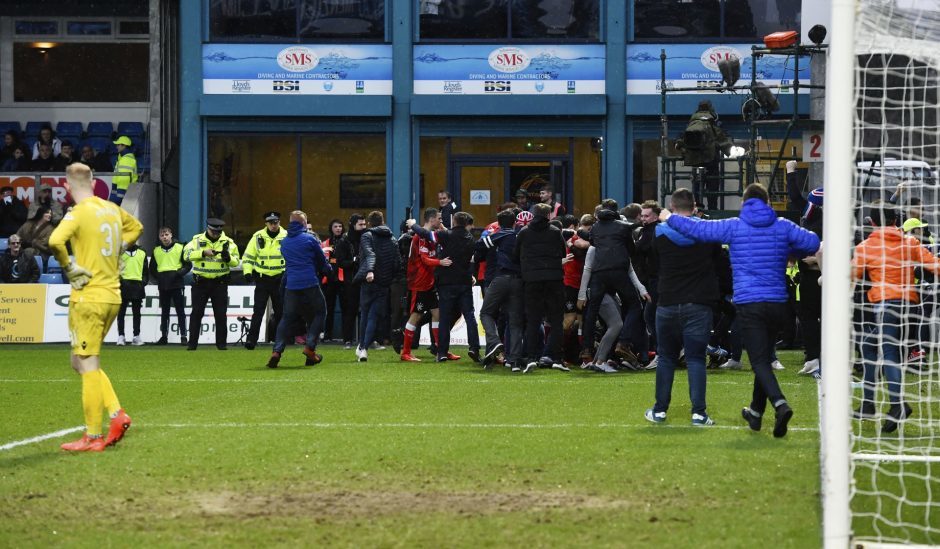 The Rangers fans make their way onto the pitch after Jason Cummings' goal.