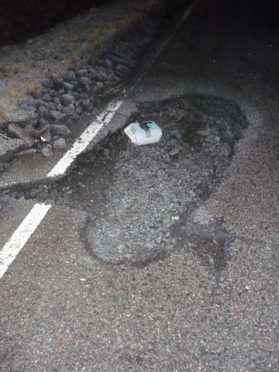 The huge pothole on the Muir of Ord to Tore road