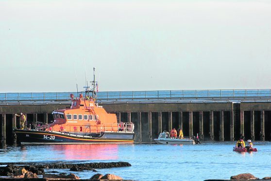 The Wick lifeboat, along with their small inflatable and another vessel search the harbour, near Scalesburn