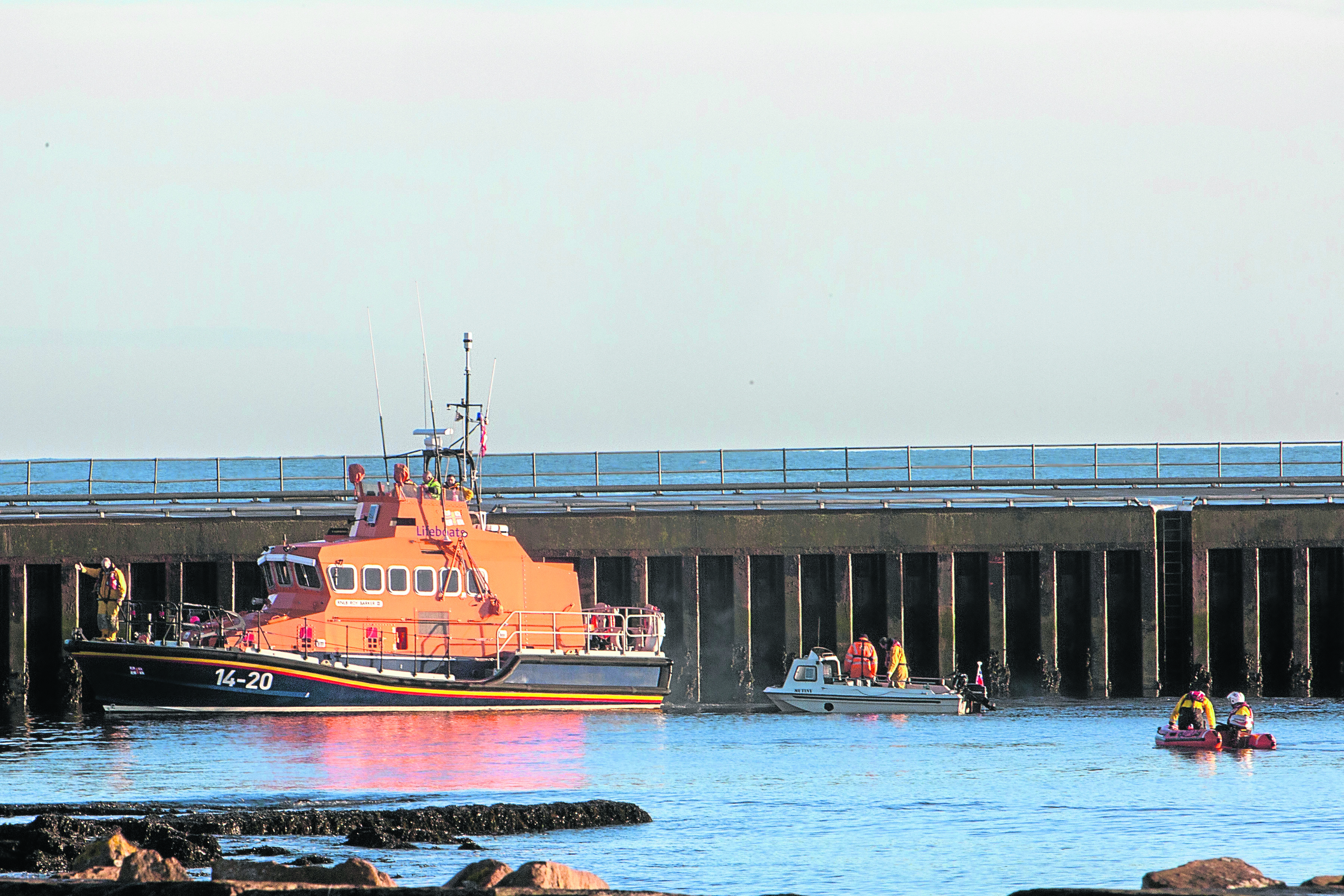 The Wick lifeboat, along with their small inflatable and another vessel search the harbour, near Scalesburn