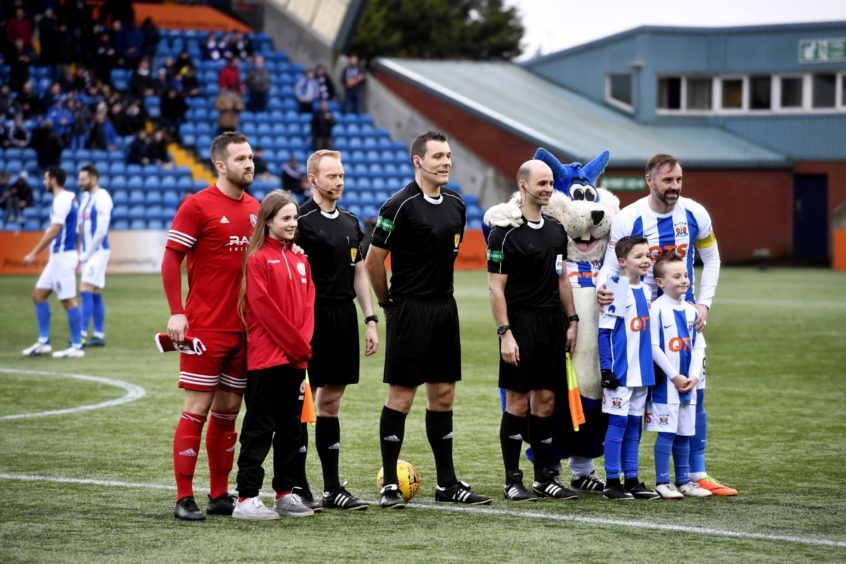 The captains pose with the match officials and mascots