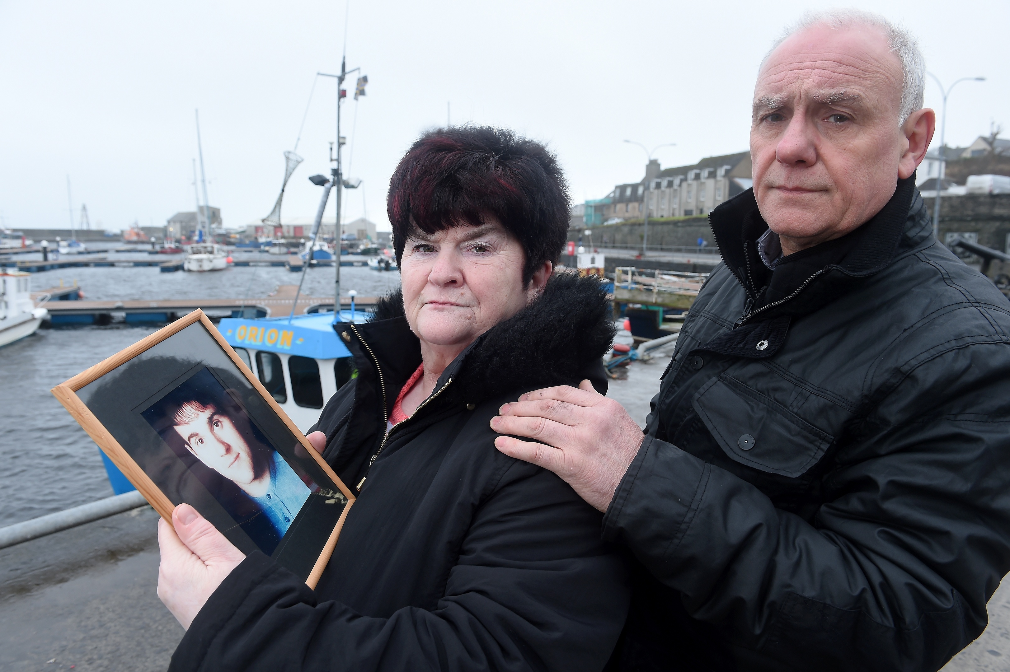 Hugh and June McLeod with a photograph of their late son Kevin at the scene in Wick Harbour  where the fatal incident took place.